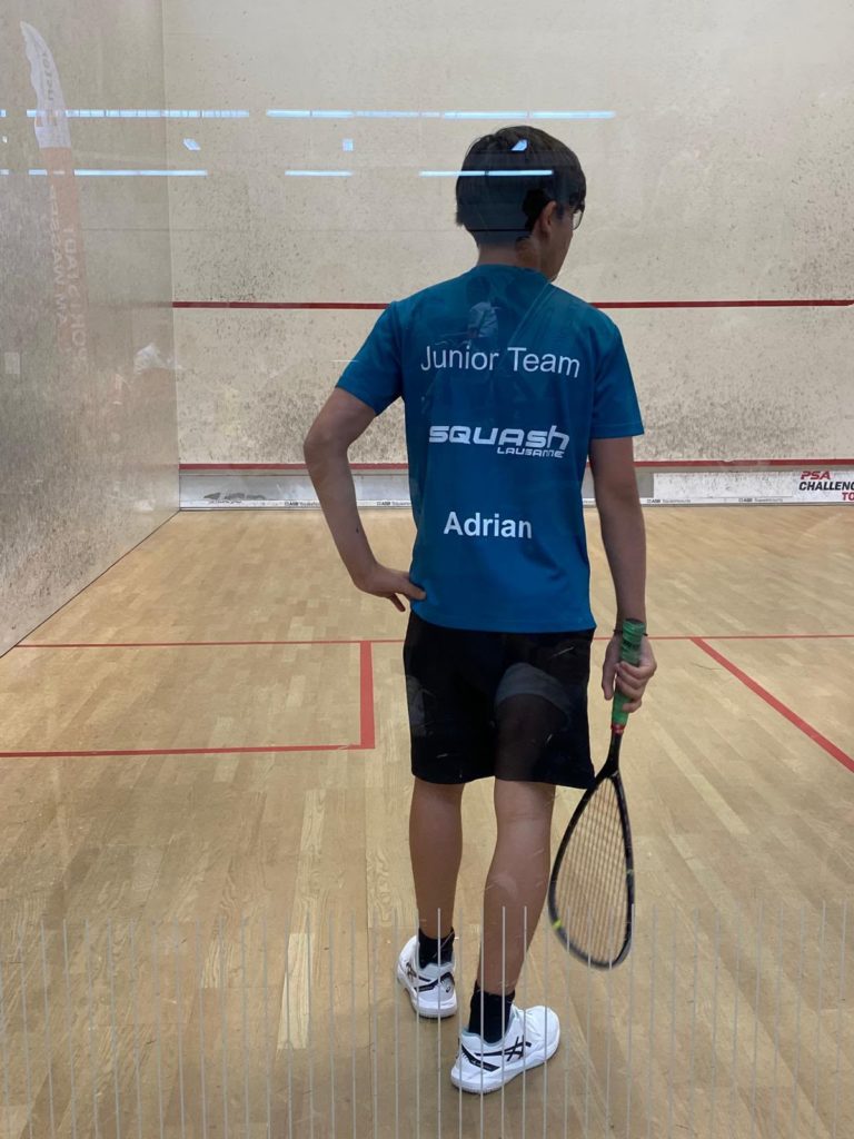 Adrian Kocsis, de dos en tenue du Junior Team, sur le court