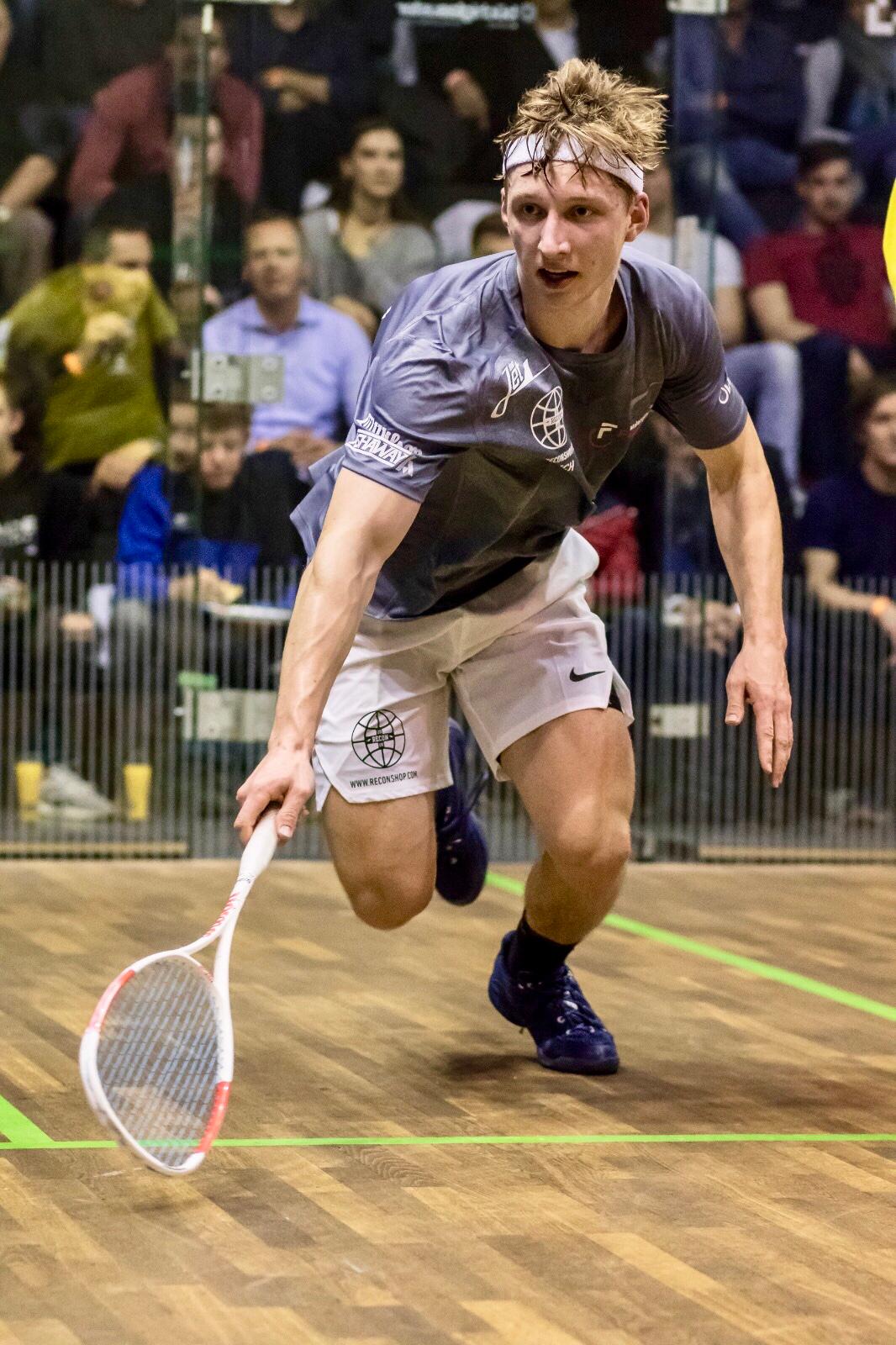 Dimitri Steinmann en pleine course sur le court, raquette tendue vers la balle