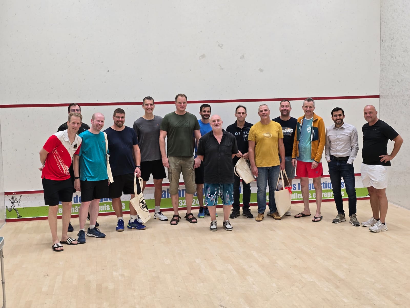 Une quinzaine de participants du tournoi de reprise du Squash Club Marin posent sur un court